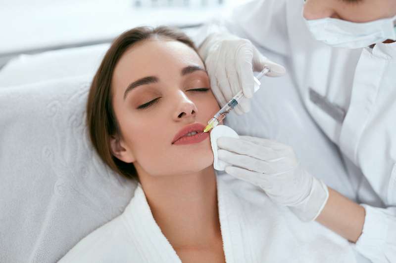young woman receiving juvederm injection for lip augmentation